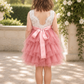 v shaped back of dress in blush flower girl dress in a tiered sleeveless tutu style. In lace and tulle. 