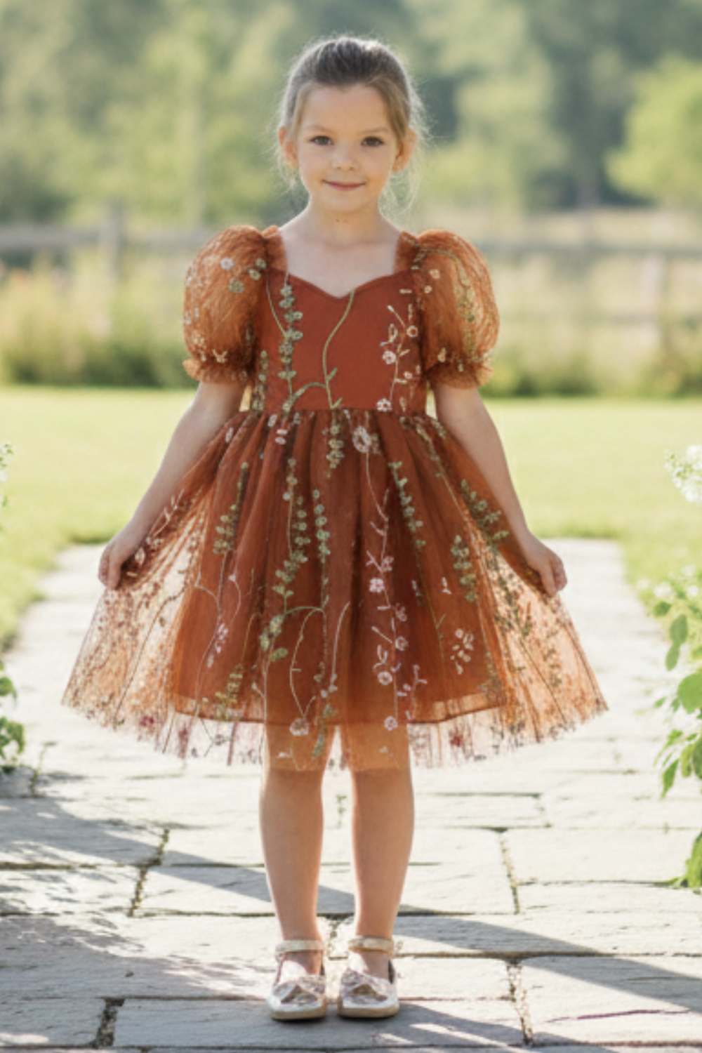 Flower Girl Dress in burnt orange floral with puffy sleeves and big bow tie in back of dress. Beautiful floral tulle