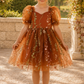 wildflower flower girl dress in embroidered floral burnt orange tulle, knee length style and big puffy short sleeves. 