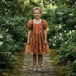 toddler flower girl dress in burnt orange floral tulle with puffy sleeves and big bow. 