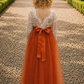 Long sleeve flower girl dress in burnt orange with lace back and matching sash