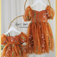 Matching sister dresses in burnt orange floral