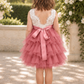 flower girl dress in dusty rose tulle in a tiered tutu style. Top bodice of a soft white lace sleeveless style dress