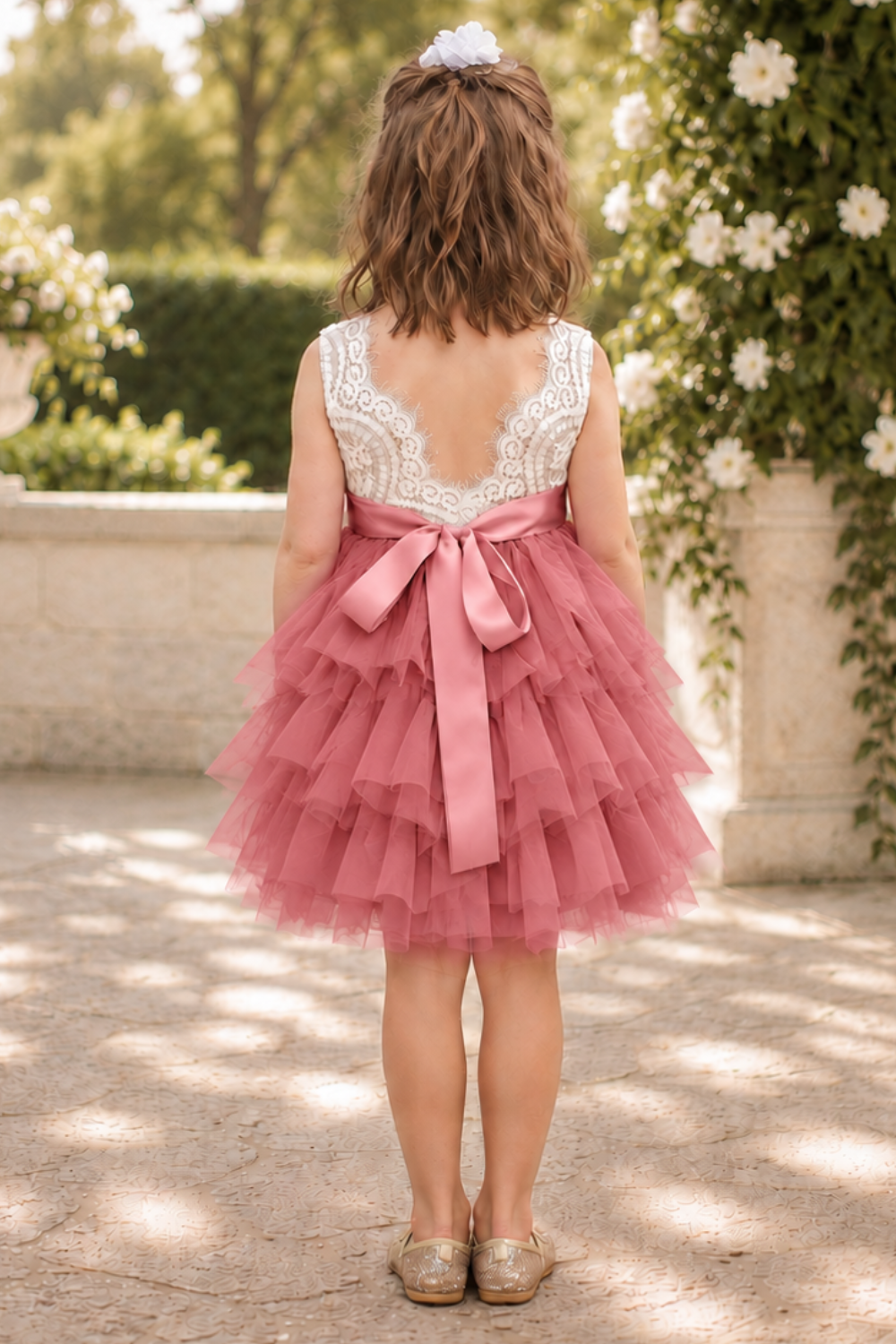 flower girl dress in dusty rose tulle in a tiered tutu style. Top bodice of a soft white lace sleeveless style dress