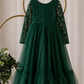 Green Christmas Dress hanging on white hanger showing long sleeve lace bodice and full tulle skirt