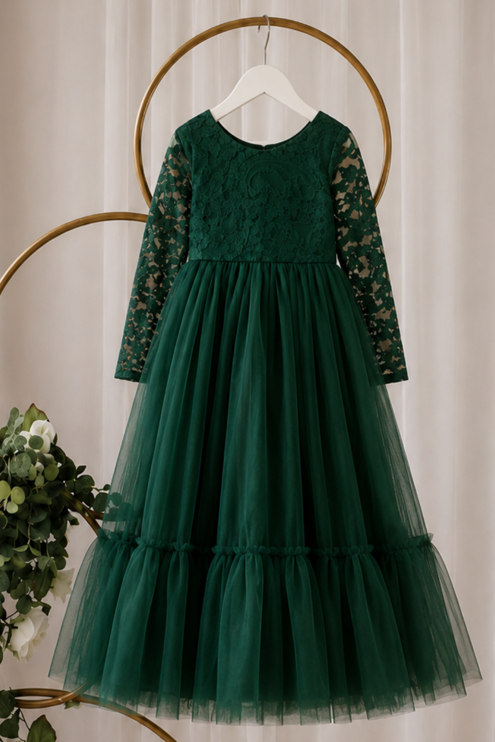 Green Christmas Dress hanging on white hanger showing long sleeve lace bodice and full tulle skirt