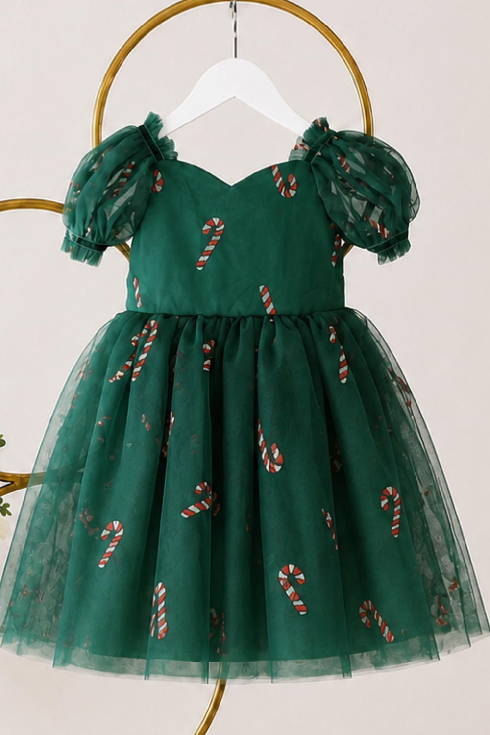 Girls Christmas outfit featuring coordinating green candy cane dresses in baby and girls sizes with puff sleeves and layered tulle.
