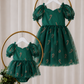 Matching sister Christmas dress in green tulle with red and gold candy cane details, puff sleeves and knee-length girls fit.