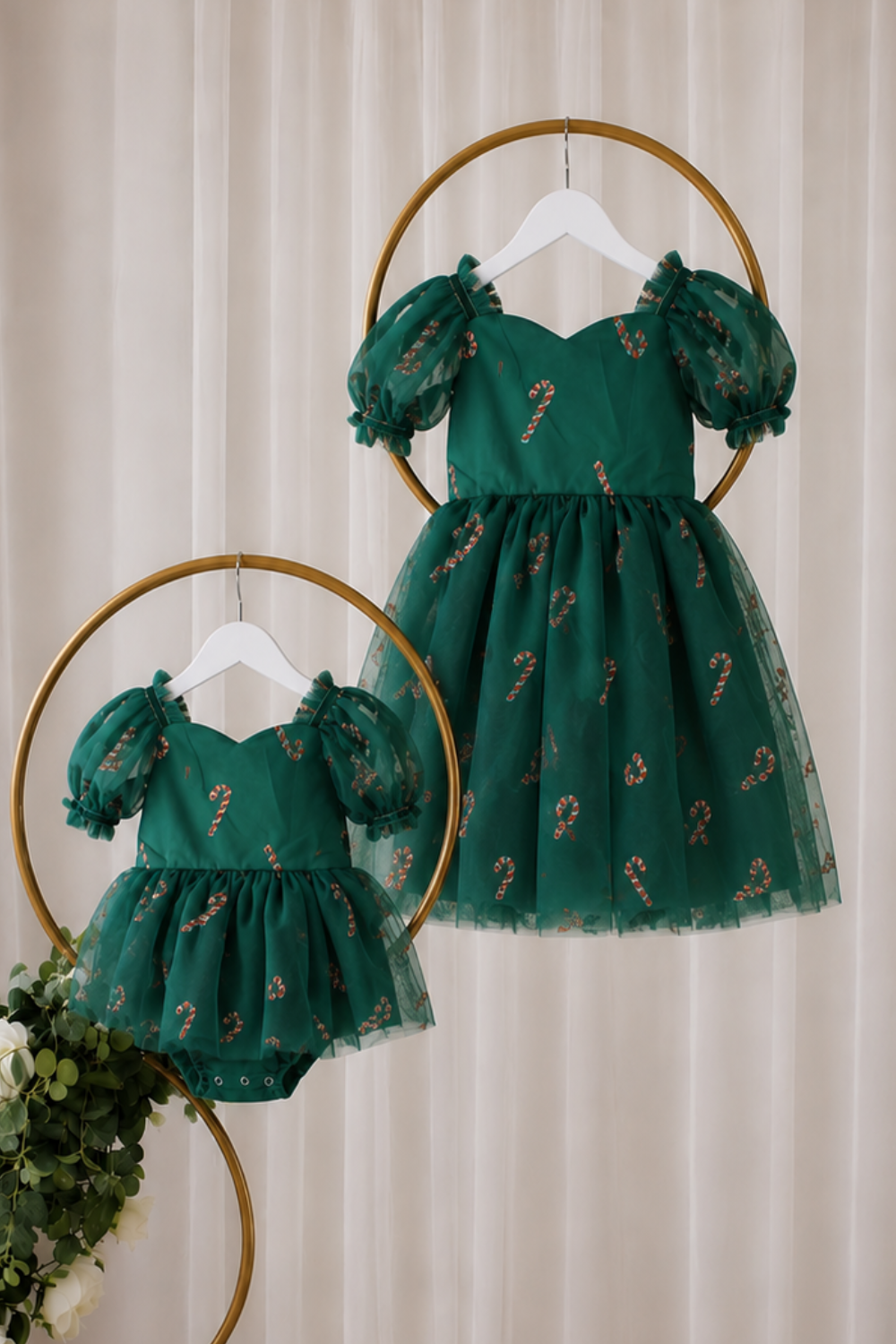 Matching sister Christmas dress in green tulle with red and gold candy cane details, puff sleeves and knee-length girls fit.