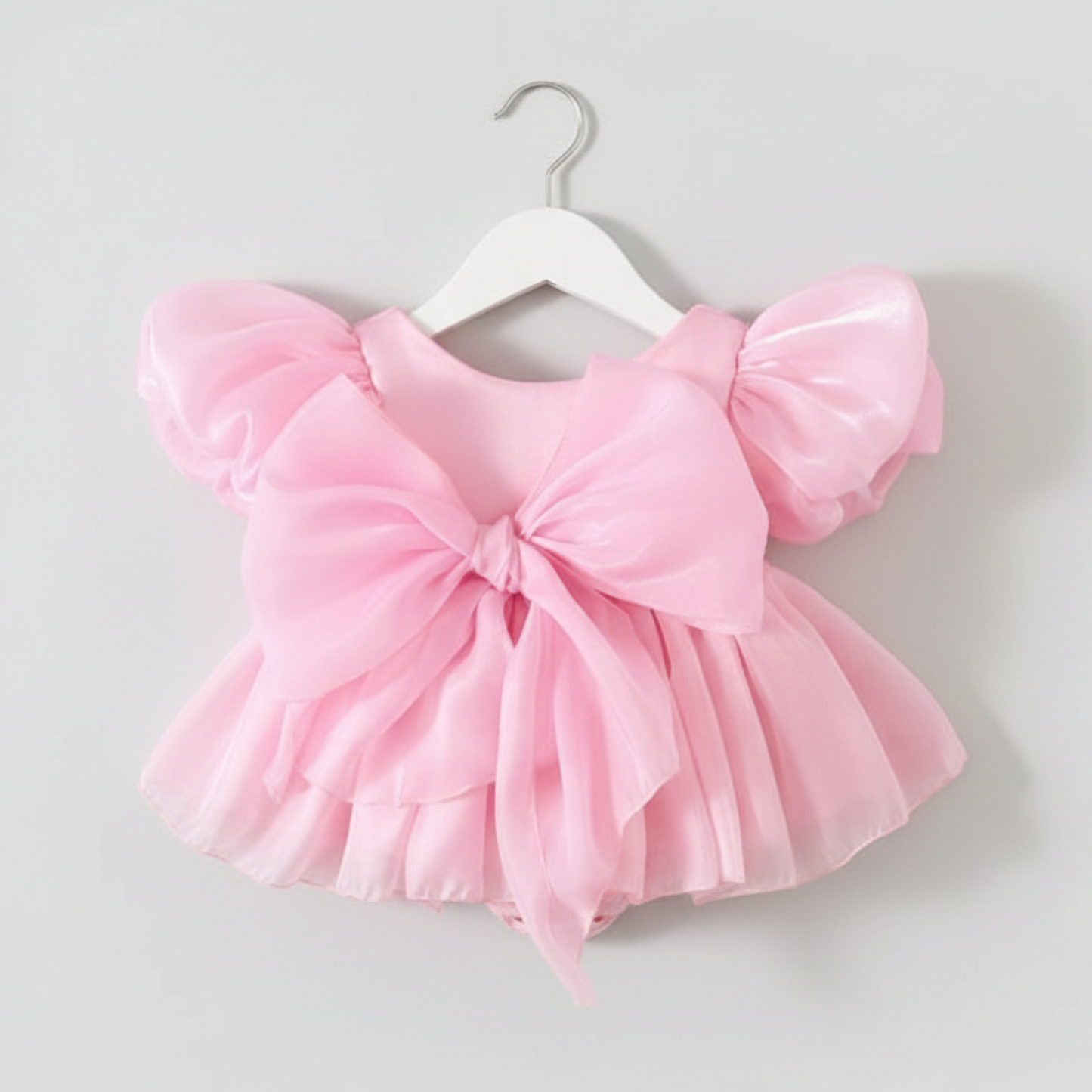 light pink baby girl dress with puffy sleeves and big bow for birthdays and special occasions. 