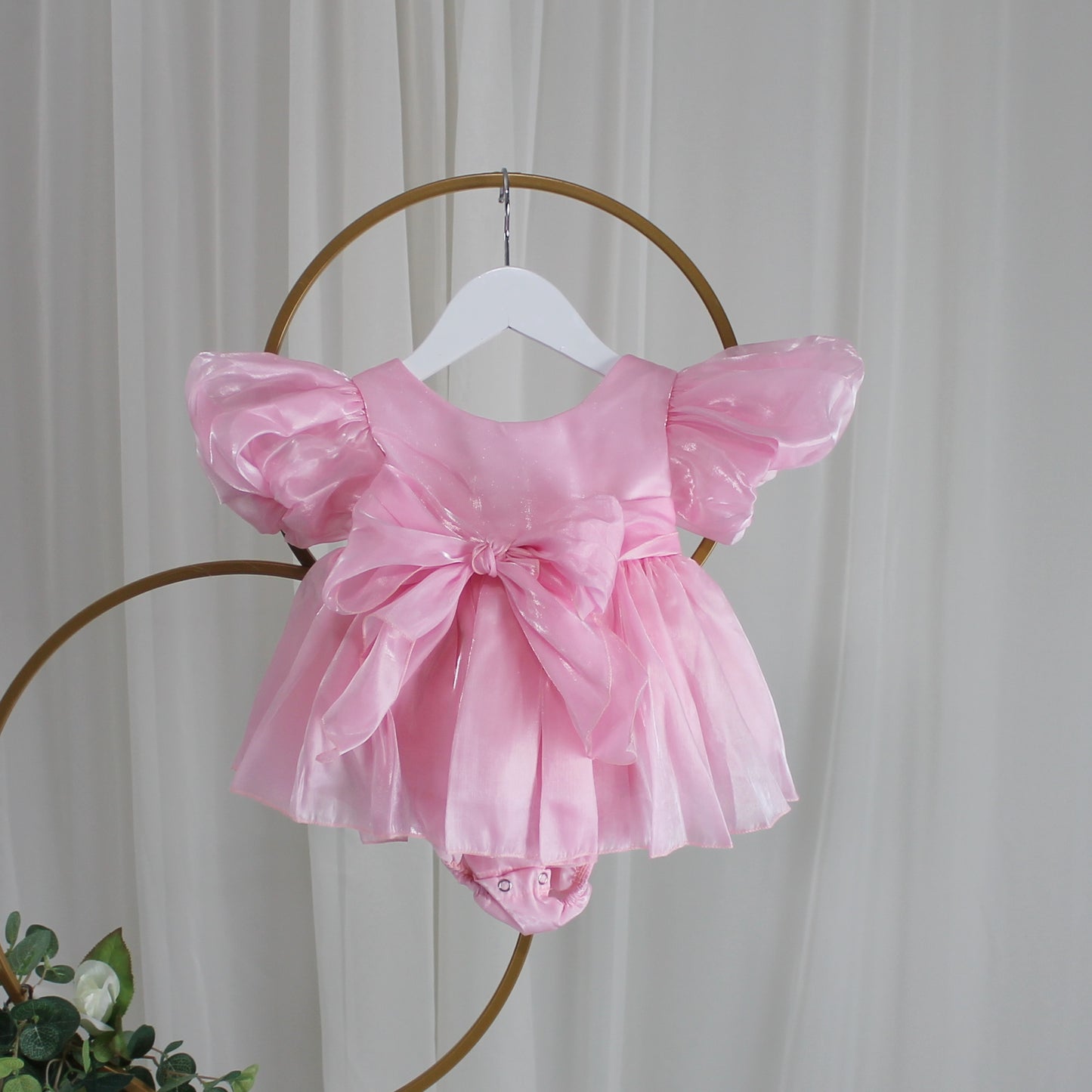light pink baby girl dress with puffy sleeves and big bow for birthdays and special occasions. 