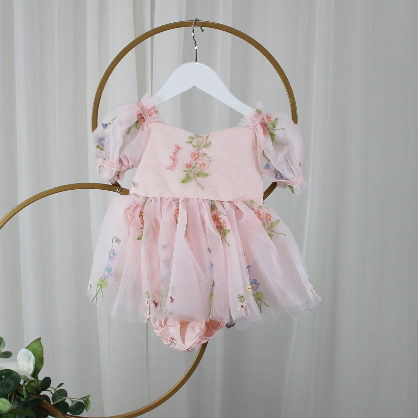 1st birthday baby girl romper in light pink floral for a fairy or garden party theme. 