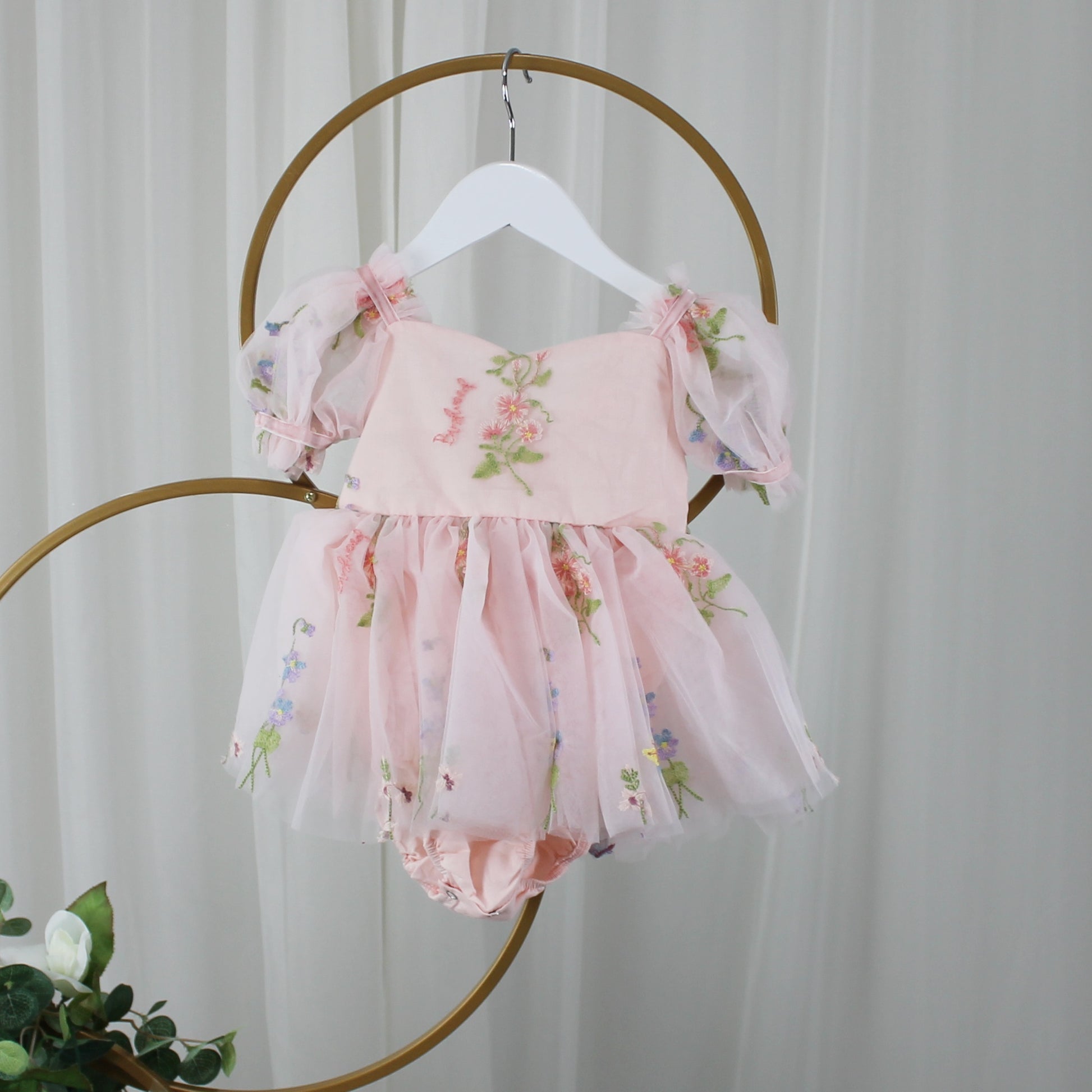 1st birthday baby girl romper in light pink floral for a fairy or garden party theme. 