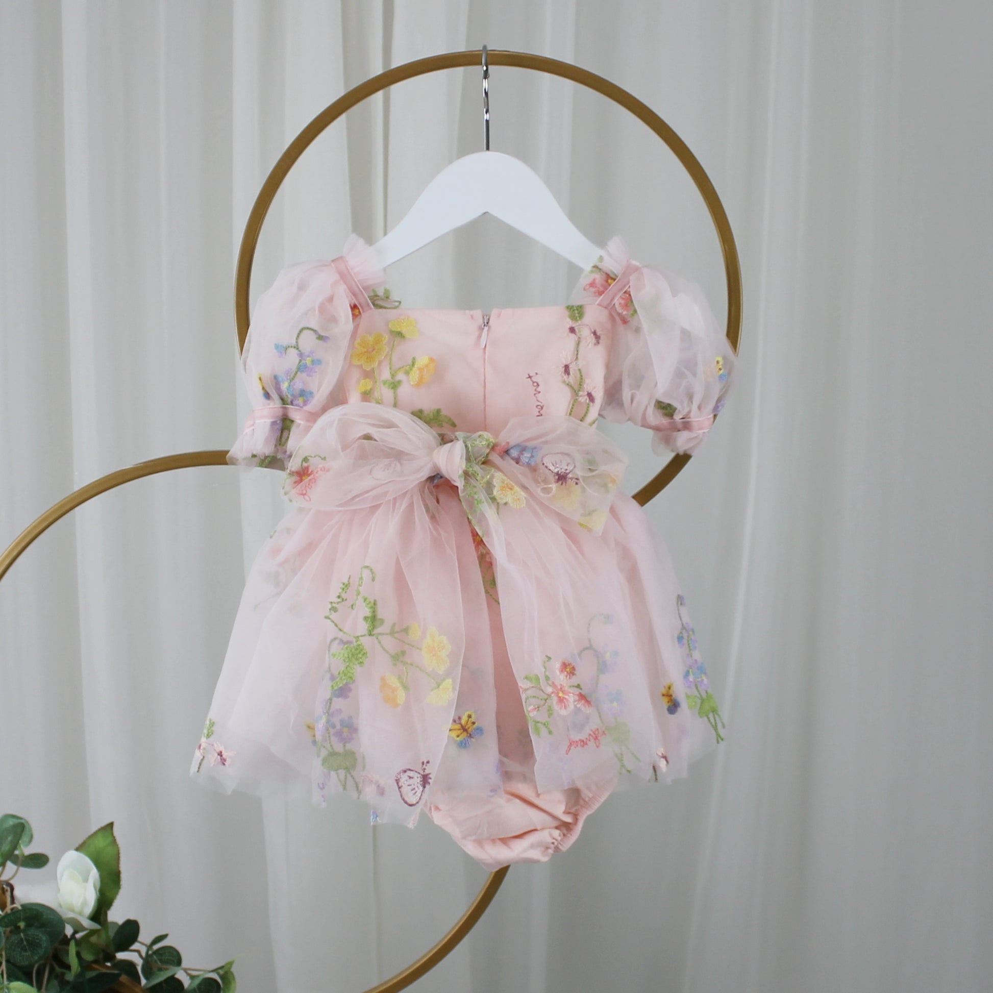 1st birthday baby girl romper in light pink floral for a fairy or garden party theme. 