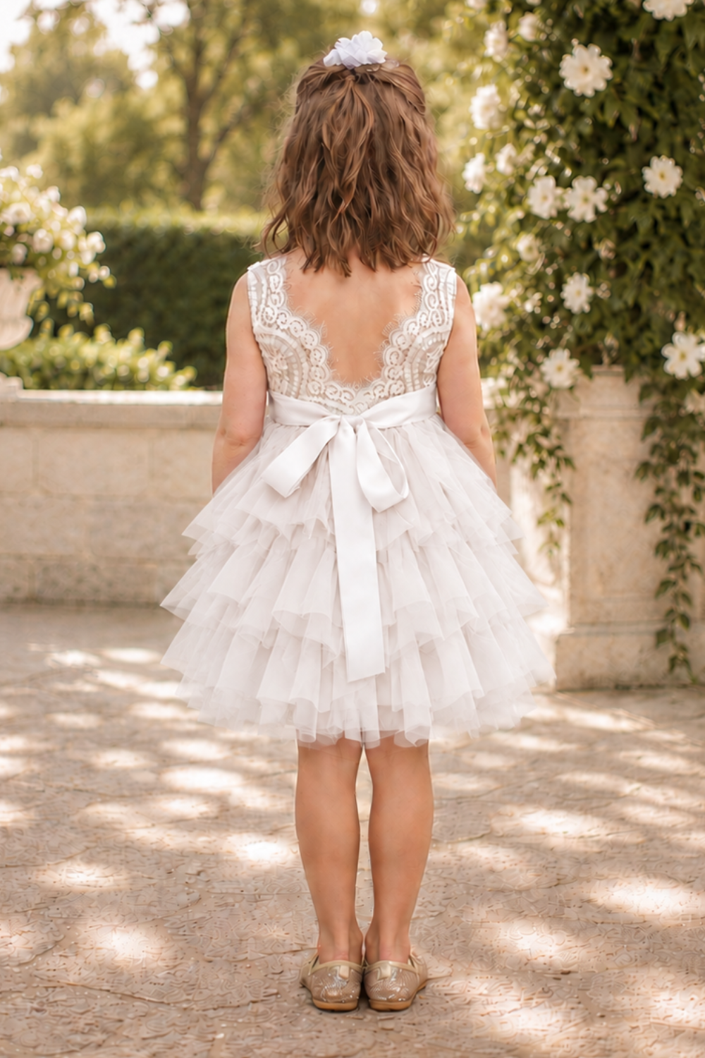 white flower girl dress in a lace and tulle. A tutu tiered style knee length dress with a sleeveless white lace bodice