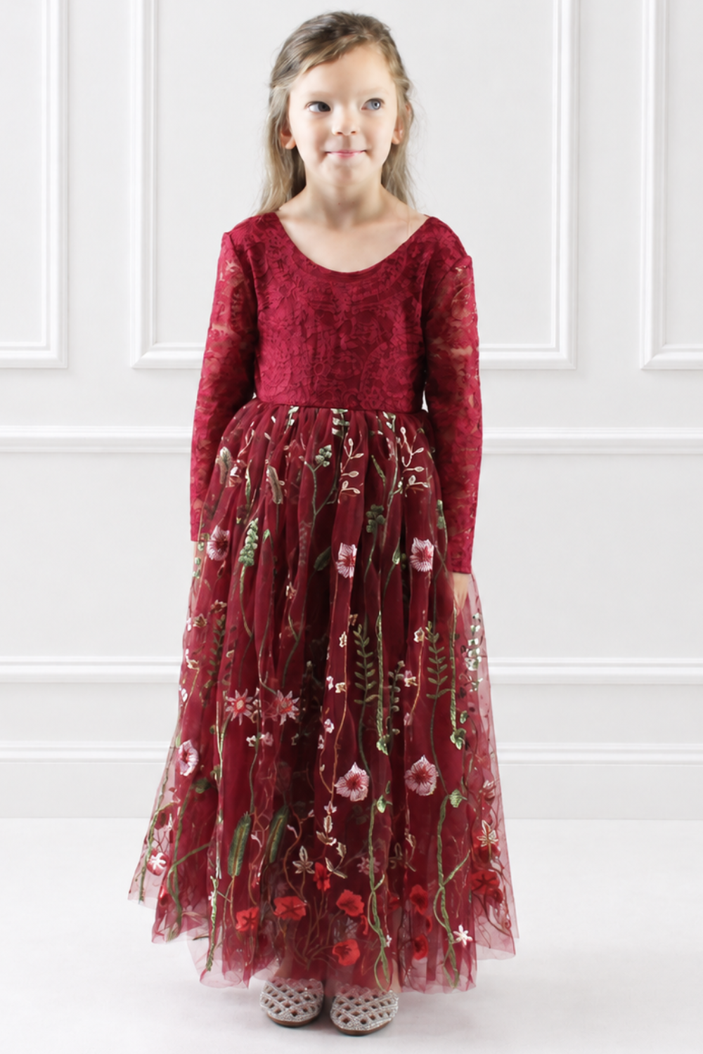 floral flower girl dress in embroidered floral burgundy tulle. Long lace sleeves and a full length style.