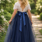 navy blue flower girl dress featuring short lace sleeves and a full length navy tulle length dress.