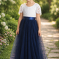 navy blue flower girl dress featuring short lace sleeves and a full length navy tulle length dress.