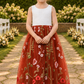Rust floral embroidered flower girl dress in a sleeveless white lace bodice and full length tulle dress. 