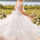 white flower girl dress in a boho style. Sleeveless lace sleeves, with a full mermaid style dress. 